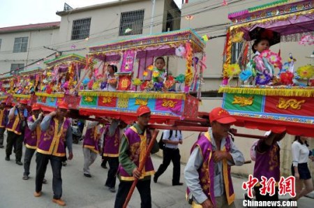 5月7日，廈門海滄蜈蚣閣民俗亮相保生大帝繞境巡安文化節(jié)。據(jù)了解，蜈蚣閣和閩臺兩地保生大帝文化密切相關(guān)，小孩子扮作金童玉女坐在“閣棚”內(nèi)，由人力肩扛，緩緩前進，猶如一條大蜈蚣蜿蜒爬行。相傳，當年保生大帝吳真人一生行醫(yī)救濟百姓，大多以蜈蚣為藥引，后人為紀念他，形成了蜈蚣閣這種祭拜民俗?！埍?攝