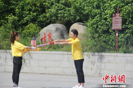 圣火采集手將火種對準圣火采集器，點亮火種燈。沈春艷 攝