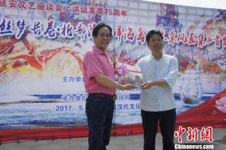 陳中華向當(dāng)?shù)夭┪镳^贈(zèng)送畫集。　韋幾云 攝