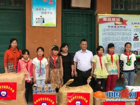 桂林僑資企業(yè)聯(lián)合會陳隆魁會長(右四)向灌陽縣水車鄉(xiāng)完小師生捐贈圖書、體育器材、教學(xué)用品等慰問物品。　陸英兵 攝
