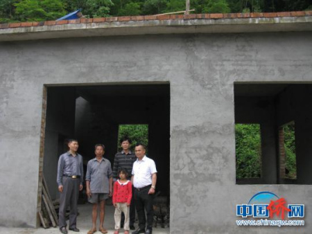 桂林市外僑辦黨組成員舒恒茂(左一)查看僑眷李洪濤危房改造項目竣工使用情況。　陸英兵 攝