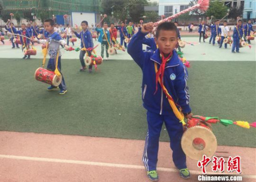 圖為孩子們背起鼓，鏗鏘有力地敲起來?！∈缝o靜 攝