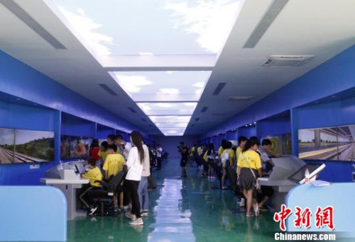 華裔青少年在模擬駕駛實(shí)訓(xùn)室?！≈炝?攝