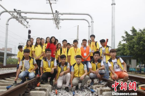 華裔青少年在軌道上合影?！≈炝?攝