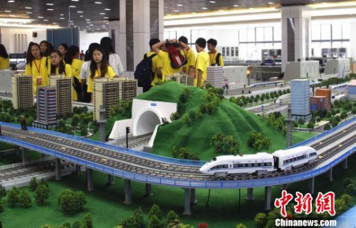 華裔青少年在觀看高鐵運(yùn)行沙盤?！≈炝?攝