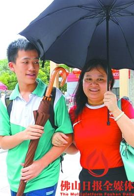 昨日12時(shí)許，一名母親手持雨傘迎接剛結(jié)束上午考試的兒子。佛山日?qǐng)?bào)記者甘建華攝