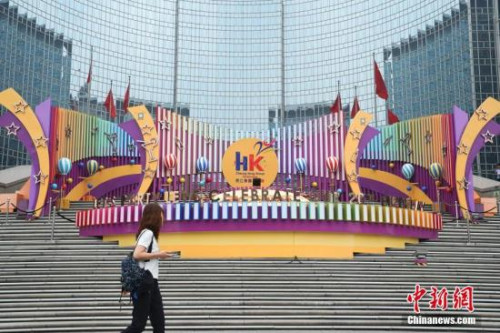 6月28日，市民從位于北京王府井東方廣場的一處慶祝香港回歸20周年的裝飾前走過。7月1日，香港特別行政區(qū)政府將迎來成立20周年紀(jì)念。<a target='_blank' >中新社</a>記者 侯宇 攝