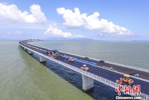 圖為6月8日，工人們在港珠澳大橋上進(jìn)行橋面鋪裝。 <a target='_blank' >中新社</a>記者 陳驥旻 攝