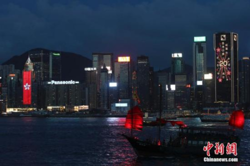 香港回歸祖國二十周年慶典臨近，香港慶回歸氣氛漸濃，6月27日晚，在維多利亞港灣兩側(cè)霓虹閃爍，大廈上的電子屏“升起”巨幅五星紅旗和紫荊花區(qū)旗，交替展現(xiàn)，并有“熱烈慶祝香港回歸祖國20周年”、“祝賀香港回歸20周年”字樣。 <a target='_blank' >中新社</a>記者 盛佳鵬 攝