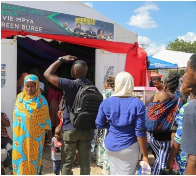 年輕人踮起腳看里面放什么電影。（非洲《華僑周報》/沈鋮賢 攝）