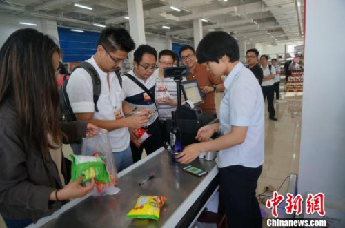 圖為華裔青年排隊為購買的進口商品付賬?！№n章云 攝