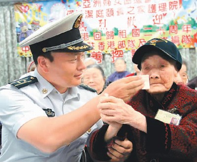 遼寧艦編隊與駐香港部隊官兵7月10日下午前往香港亞洲婦女協(xié)進會頤養(yǎng)之家護理院看望并慰問老人。已經(jīng)在護理院住了18年的110歲老人謝月瓊，興奮地豎起大拇指，留下了激動的淚水。圖為遼寧艦編隊官兵細心地為老人擦去淚水。 　　辜雨晴攝