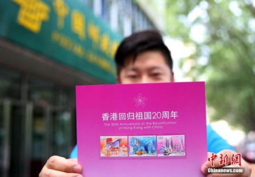 資料圖：2017年7月1日，北京集郵愛好者展示《香港回歸祖國二十周年》紀念郵票。當日，為慶祝香港回歸祖國二十周年，中國郵政發(fā)行《香港回歸祖國二十周年》紀念郵票。 <a target='_blank' >中新社</a>記者 卞正鋒 攝