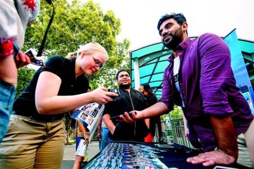 圖為HanNation的團(tuán)隊(duì)成員塞舍爾（右）在校園里向留學(xué)生推介他們的APP。