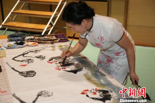 圖為“2017年中華文化大樂(lè)園--日本橫濱夏令營(yíng)”優(yōu)秀教師團(tuán)的陳聰老師在開(kāi)營(yíng)式上現(xiàn)場(chǎng)創(chuàng)作國(guó)畫(huà)作品。　尹法根 攝