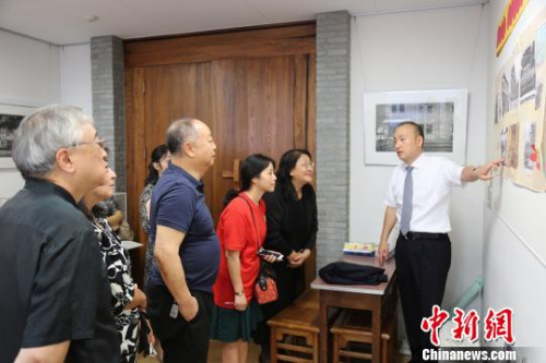 圖為橫濱山手中華學(xué)校校長(zhǎng)張巖松(右一)向嘉賓們介紹百年校史?！∫ǜ?攝