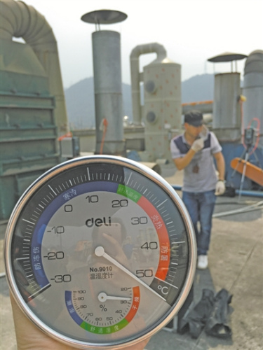 下午2時(shí)30分，鹿城環(huán)保工作人員在企業(yè)樓頂監(jiān)測(cè)排氣數(shù)據(jù)，溫度超過(guò)50℃。 張琳 攝