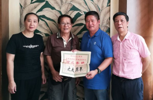 容榮仲先生(左二)向江門市博物館館長黃志強(qiáng)捐贈史料，右一為容樹榮先生(容榮仲在江門生活的侄兒)，左一為江門市博物館副館長林軍