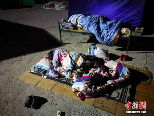8月10日凌晨2時許，記者抵達四川阿壩州九寨溝地震災區(qū)，隨即走進永樂鎮(zhèn)清平三村村委會、梨花廣場避難場所探訪，眾多民眾為躲避余震，一家人擠在一起睡在露天廣場，深夜氣溫僅有13度。<a target='_blank'  >中新網(wǎng)</a>記者 陳文 攝