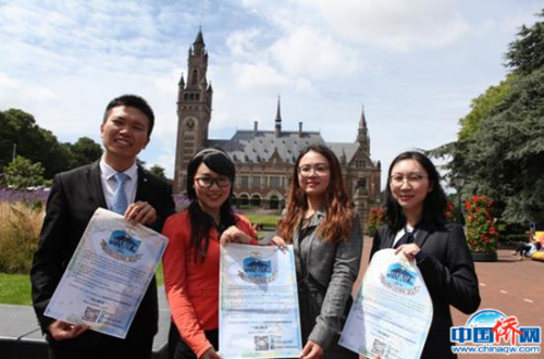 (圖為旅荷國際法學(xué)學(xué)者海牙和平宮前展示海報，宣傳他們針對南海仲裁案撰寫的公開信，尋求國際法正義，左二穿紅衣者是作者彭芩萱。作者供圖)