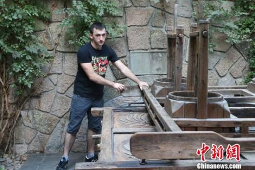 圖為：德國(guó)漢諾威孔子學(xué)院學(xué)生體驗(yàn)四桶茶葉揉捻機(jī)。　王瀟婧 攝