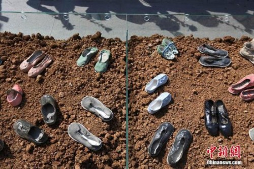 資料圖：4月3日，2017年“清明祭”系列活動(dòng)——陶藝鞋展開(kāi)展儀式在侵華日軍南京大屠殺遇難同胞紀(jì)念館雕塑廣場(chǎng)舉行，現(xiàn)場(chǎng)展示南京曉莊學(xué)院附屬小學(xué)教師王成創(chuàng)作的陶瓷鞋80雙，寓意南京大屠殺慘案發(fā)生80周年，以此形式祭奠遇難同胞。圖為祭奠現(xiàn)場(chǎng)。(圖片來(lái)源：<a target='_blank'  >中新網(wǎng)</a>/ 泱波 攝)