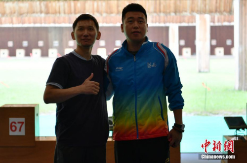  8月28日，天津團(tuán)泊體育中心射擊館，美籍華人選手石晶參加第十三屆全國運(yùn)動(dòng)會(huì)男子50米手槍預(yù)賽，位列第18名。圖為賽后，石晶（左一）和龐偉合影留念。 <a target='_blank' >中新社</a>記者 翟羽佳 攝