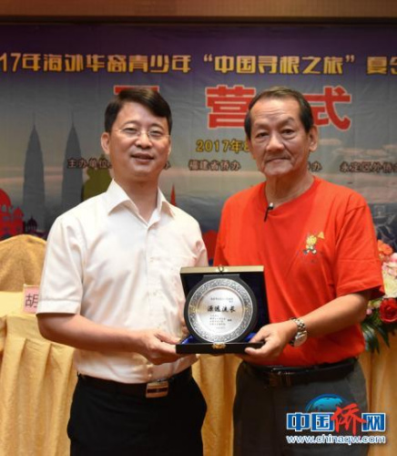 圖為王小慶代表永定區(qū)委、區(qū)政府接受羅良斌贈(zèng)送的紀(jì)念品。　劉永良 攝