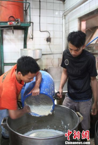 圖為工人正在磨豆?jié){。　林永傳 攝