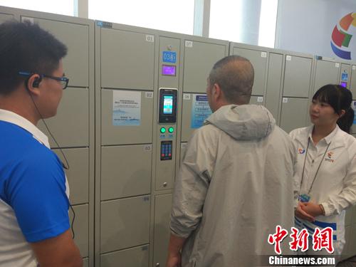 志愿者幫助記者使用電子儲(chǔ)物柜。<a target='_blank'  >中新網(wǎng)</a>記者 李金磊 攝