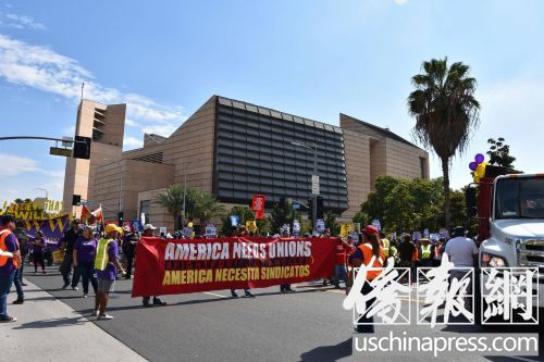 游行隊(duì)伍中人們舉著各自不同的標(biāo)語，但口號一致是不同族裔一同追求公正。（美國《僑報》/翁羽 攝）