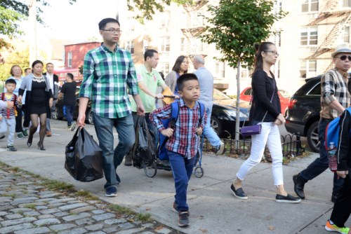 華裔家長當(dāng)起“挑夫”，拎著大包小包文具帶孩子上學(xué)。（美國《世界日報(bào)》/朱澤人 攝）