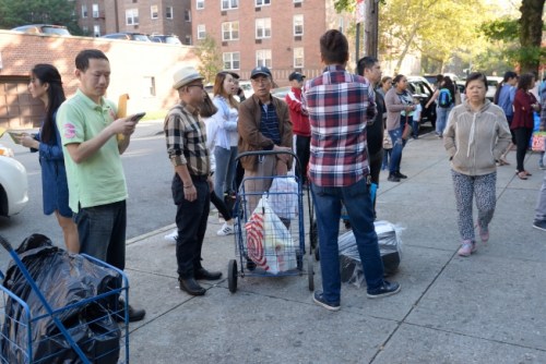 法拉盛家長推著裝滿文具的菜籃車，等著放入校園置物柜。（美國《世界日報(bào)》/朱澤人 攝）