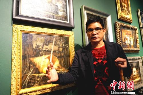 畫展的主人、菲律賓畫家阿瑞奧拉(DANILO ARRIOLA)每天坐在輪椅上迎接參觀者。 關向東 攝