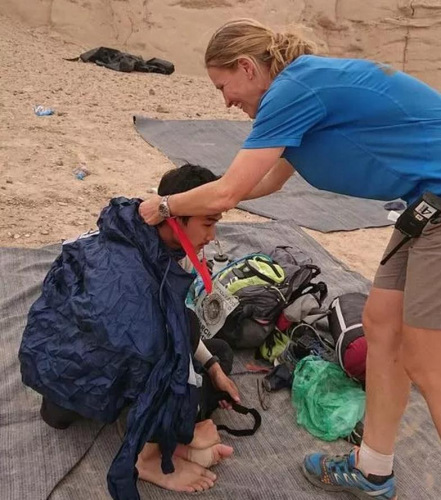 賽事總監(jiān)細(xì)心為體力不支的宋智亮(左)戴上獎(jiǎng)牌，讓遠(yuǎn)在異鄉(xiāng)的他倍感溫馨。(馬來(lái)西亞《星洲日?qǐng)?bào)》)