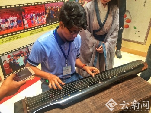 孟加拉國少年在彈奏古琴。