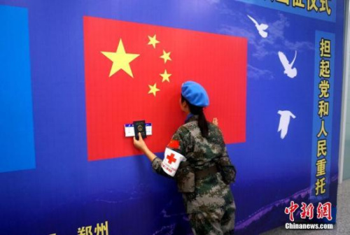 一名維和女兵出征前親吻五星紅旗。 李志全 攝