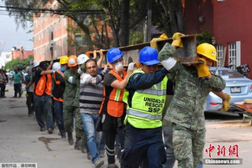 救援人員從震后廢墟中救出了50多人，墨西哥總統(tǒng)培尼亞在全國講話中稱，眼下的當(dāng)務(wù)之急是救人，堅(jiān)信仍然可能從廢墟中救出更多生還者。圖為救援隊(duì)員合力抬一根鐵梁。