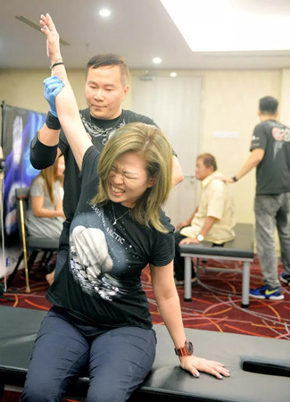 梁潤(rùn)江為獅城客萬(wàn)鳳儀進(jìn)行五十肩的治療。（馬來(lái)西亞《星洲日?qǐng)?bào)》）