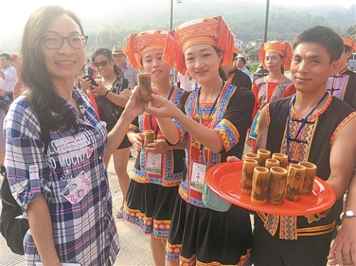在夏宜瑤族鄉(xiāng)，游客們剛進(jìn)寨門就嘗到香醇的米酒。 本報(bào)記者 梁乾勝/攝
