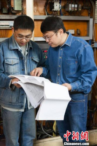 鄧建軍傳授徒弟技術(shù)要領(lǐng)。江蘇常州黑牡丹(集團(tuán))股份有限公司供圖。