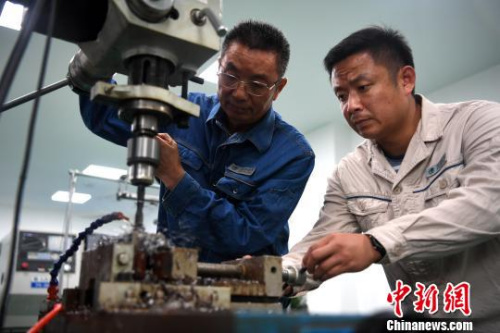 許啟金和徒弟吳偉在工作室中研制工具。　韓蘇原 攝