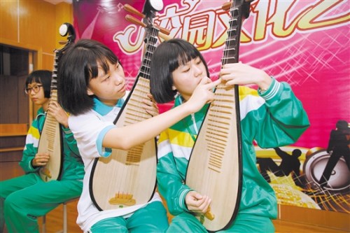 李樹芬紀(jì)念中學(xué)民樂班的學(xué)生在交流彈奏技藝。