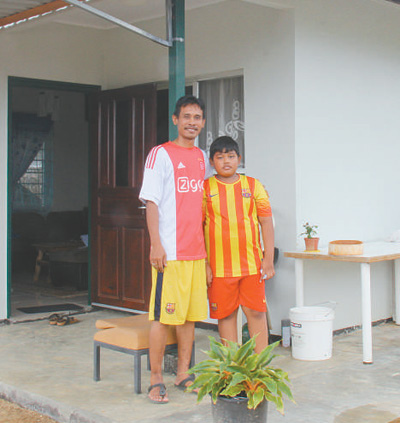 塔諾阿萊客索諾·阿萊克斯和兒子在新房前合影。 　　本報(bào)記者 顏 歡攝