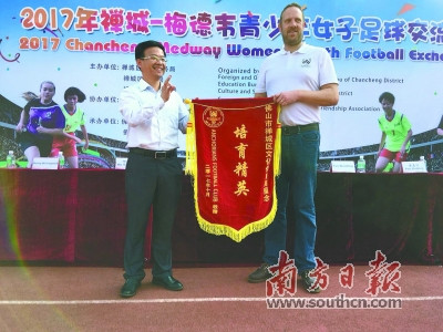 英國(guó)梅德韋市安卡利亞球會(huì)會(huì)長(zhǎng)李·威利斯金向禪城區(qū)文化體育局代表贈(zèng)予錦旗。梁志毅 攝