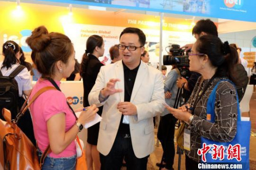 展臺(tái)工作人員認(rèn)真解答學(xué)生及家長(zhǎng)的問(wèn)題。　趙婧楠 攝