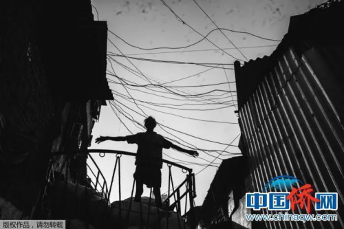 “相機(jī)攝”印度達(dá)拉維貧民窟，貧民窟中的一個(gè)搬運(yùn)工，不知道他這個(gè)動(dòng)作是為了伸展一下四肢還是有貨物丟了下來。但在這一刻，我仿佛看見了上帝。