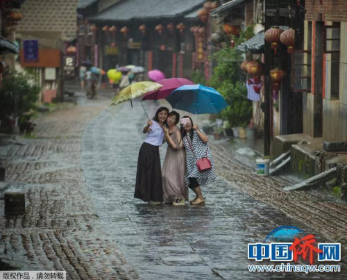 “相機(jī)攝”湖南永州市零陵老街，三位美女在雨中的老街玩自拍。