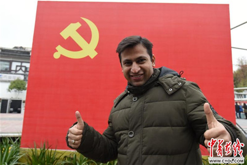 巴科在中國(guó)共產(chǎn)黨黨旗下豎起大拇指。吳蔚/攝