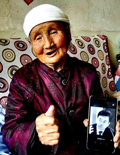 一位受害者舉著童增的照片。